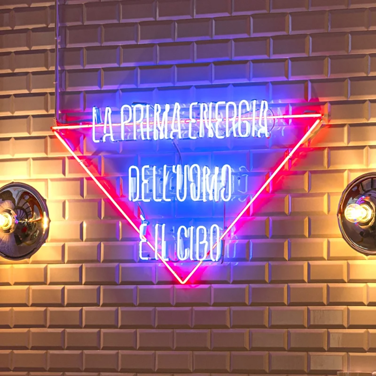 Insegna luminosa al neon all'interno di un ristorante ALT: La prima energia dell'uomo è il cibo